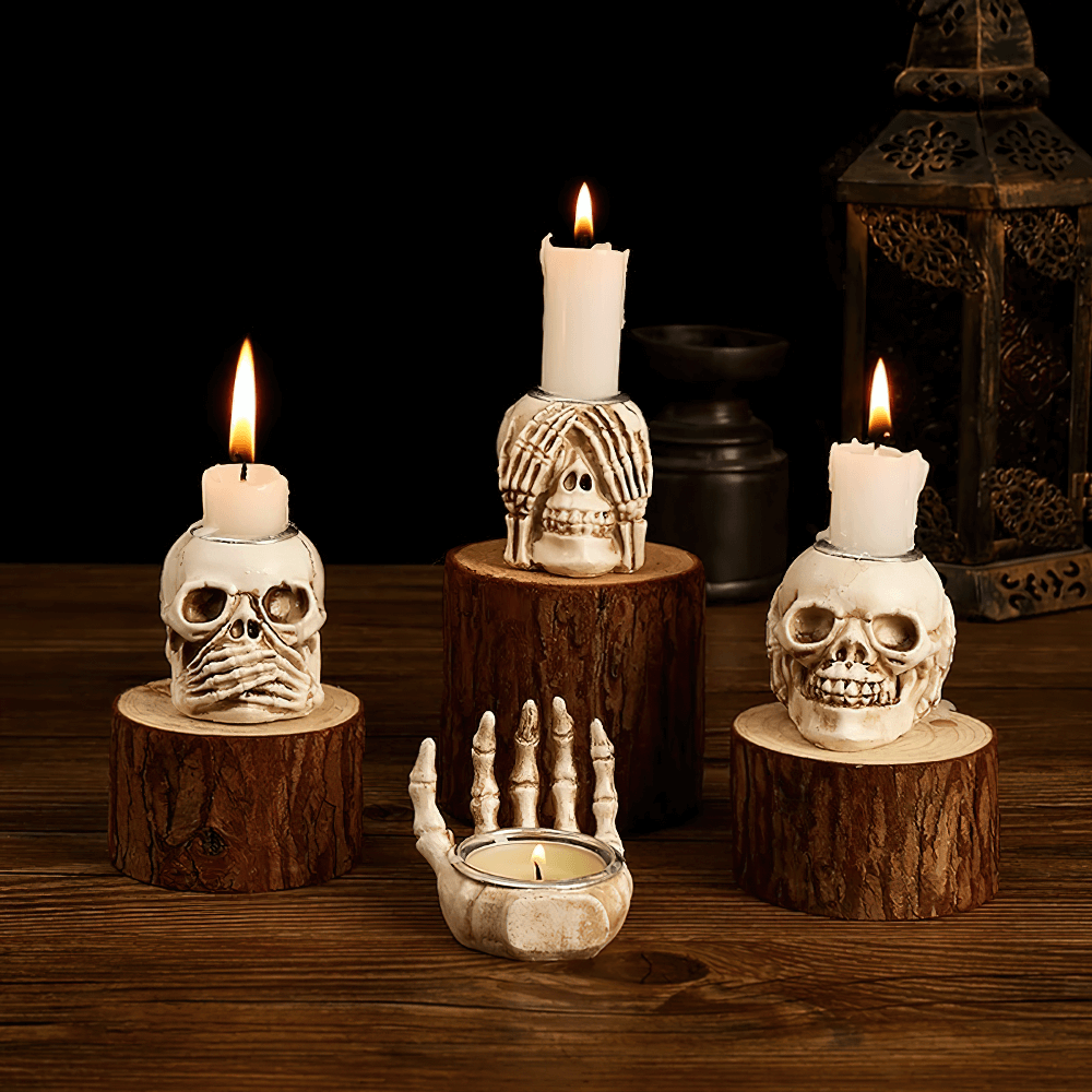Skull candle holders set with skeleton hands and candles, perfect for gothic Halloween decor.