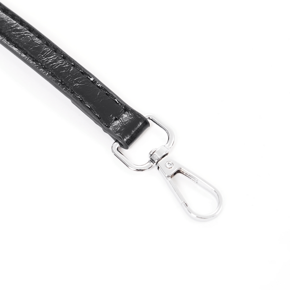 Close-up of a black faux leather strap with a silver clasp for a gothic tote bag.