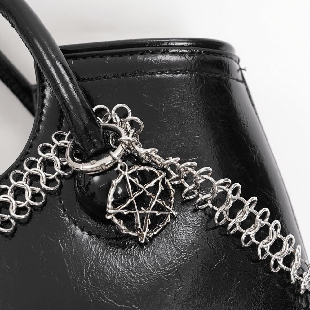 Close-up of gothic tote bag featuring chain link detail and silver skull charm, showcasing edgy style.