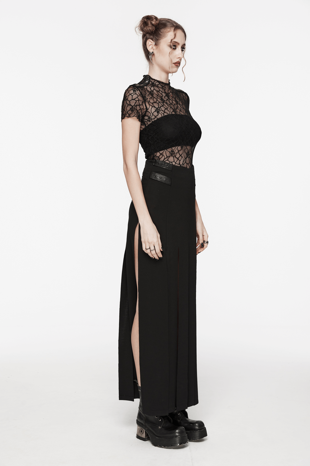 Woman modeling a black skull mesh short-sleeved punk T-shirt paired with a long skirt and chunky boots.