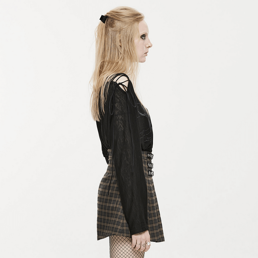 Side view of a stylish punk long sleeve top with skull print and lace-up details, paired with a checkered mini skirt.
