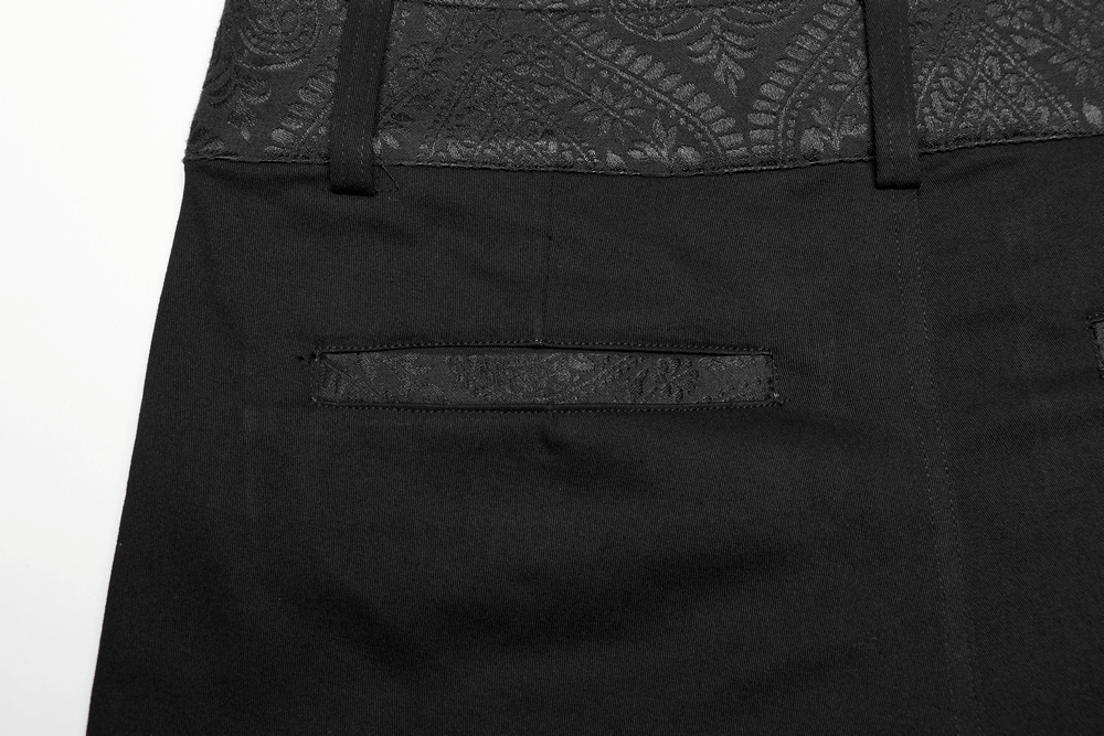 Close-up of sleek black gothic trousers featuring webbing detail and discreet side seam pockets.