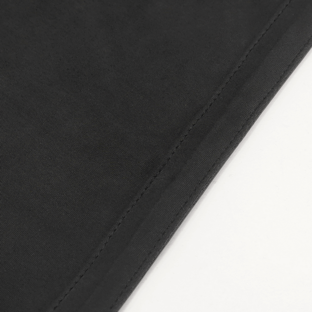 Close-up of sleek black fabric showcasing the smooth texture of a stylish maxi skirt.
