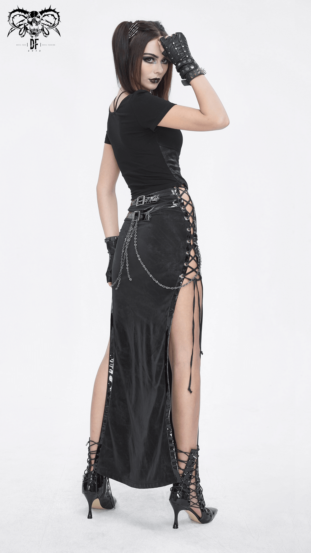 Chic model showcasing a sleek black maxi skirt with side lacing details and edgy gloves, perfect for a bold fashion statement.