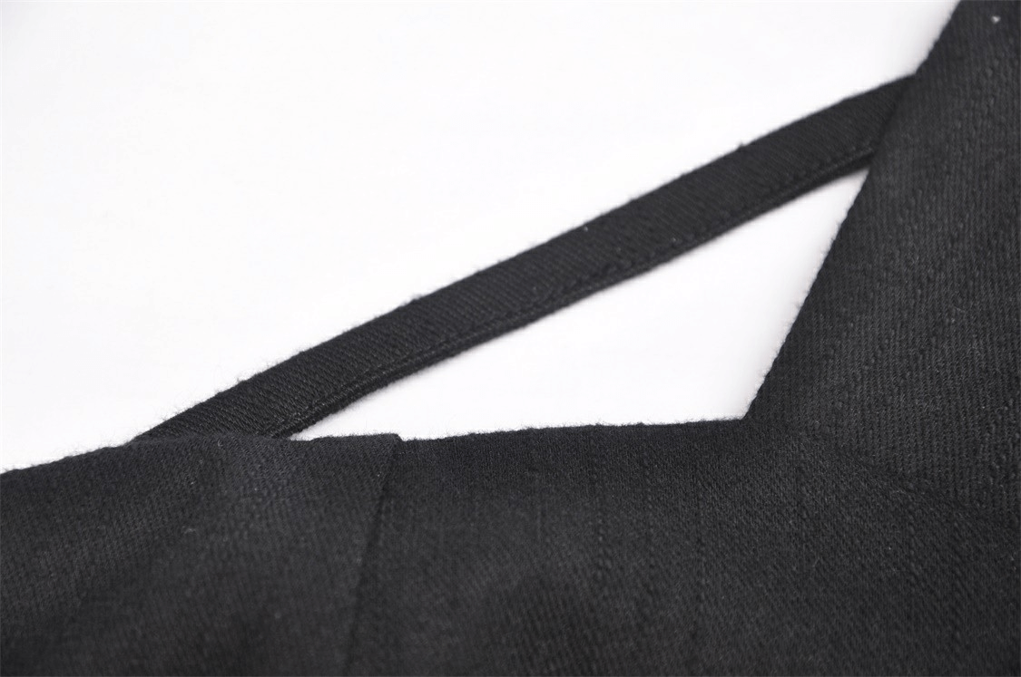 Close-up of sleek black crop top showcasing zipper and belt accent details for a trendy look.