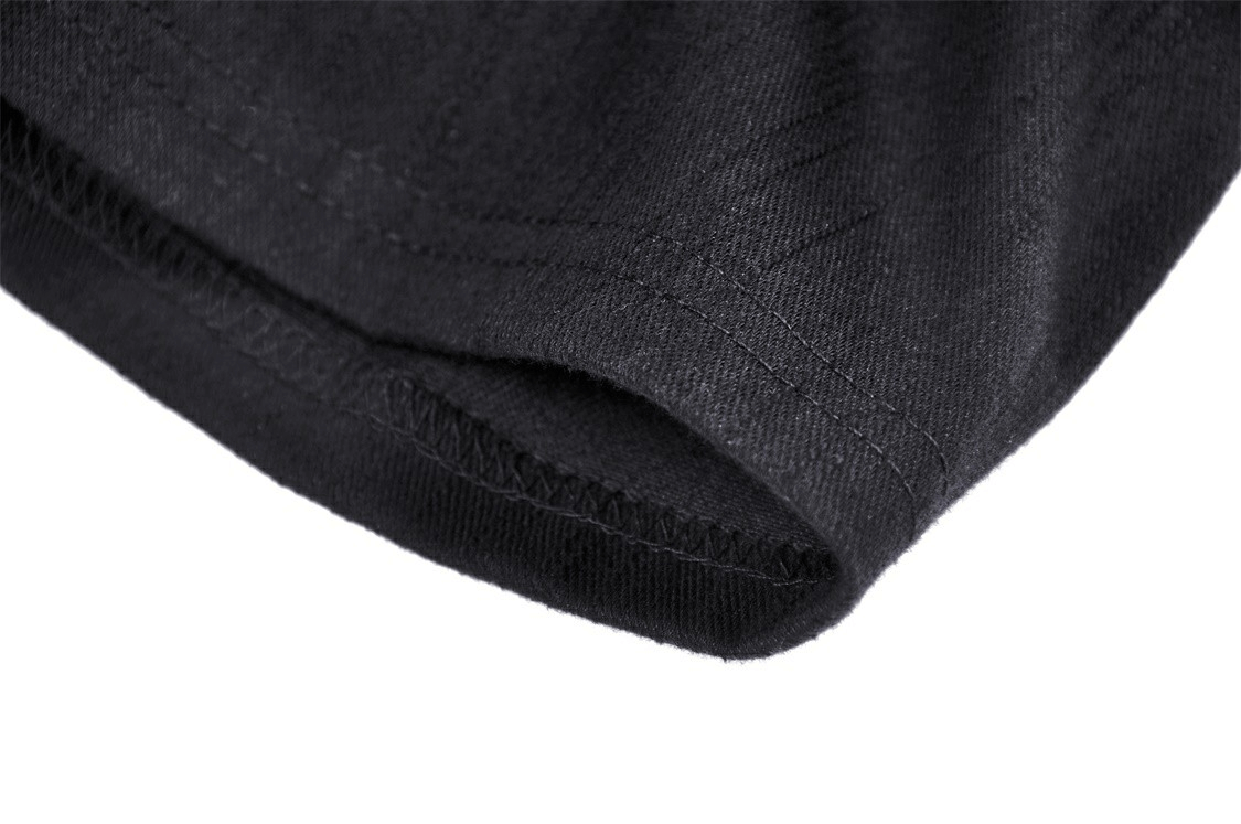 Close-up of sleek black fabric showing the hem and stitching details of a stylish crop top.