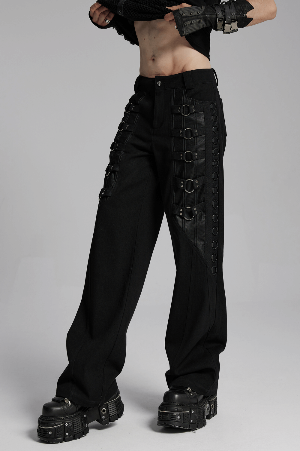 Sleek Gothic black pants with metal loops, perfect for a punk-style look, paired with platform boots.