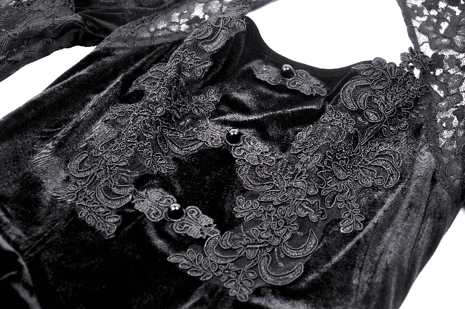 Close-up of a sleek gothic lace dress with velvet accents, featuring intricate embroidery and button details.