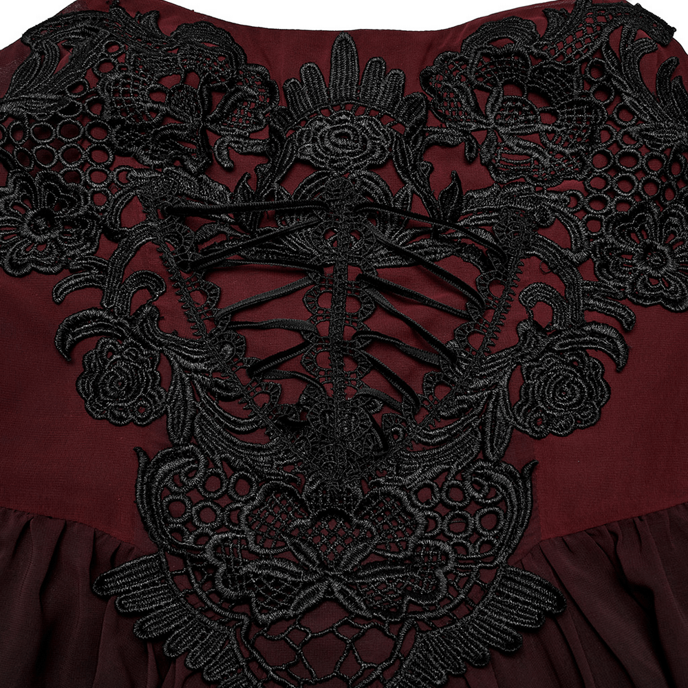 Intricate black lace embroidery on a dramatic burgundy dress back with adjustable lace-up detail.
