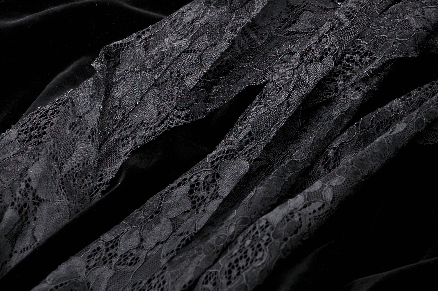 Intricate black lace fabric swatches showcasing delicate patterns, perfect for gothic-inspired fashion designs.