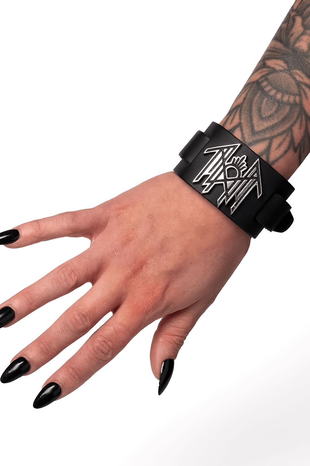 Close-up of Sleep Token black leather bracelet with pewter logo on a tattooed hand, showcasing its bold design.