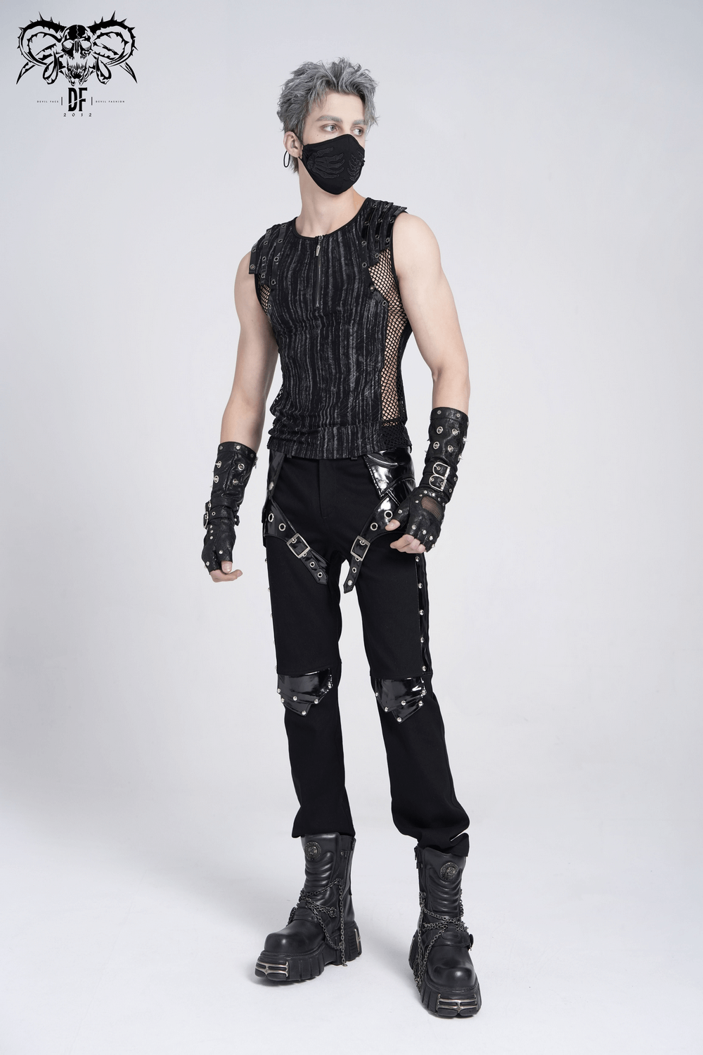 Model wearing a sleeveless gothic top with mesh sides, buckle straps, and grunge-inspired black pants.