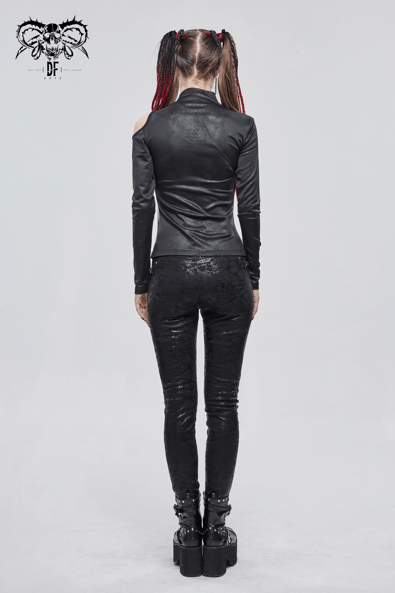 Back view of a woman in a gothic black long sleeve cutout top paired with stylish black pants.