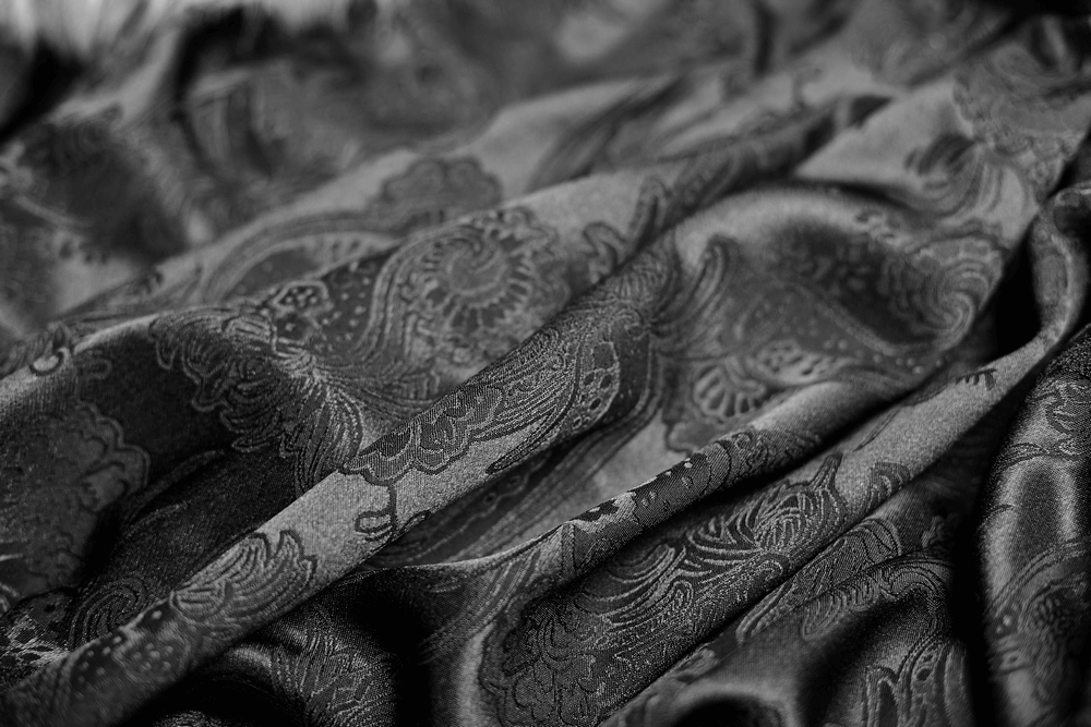 Luxurious black gothic fabric with intricate paisley patterns, perfect for a sophisticated cloak.