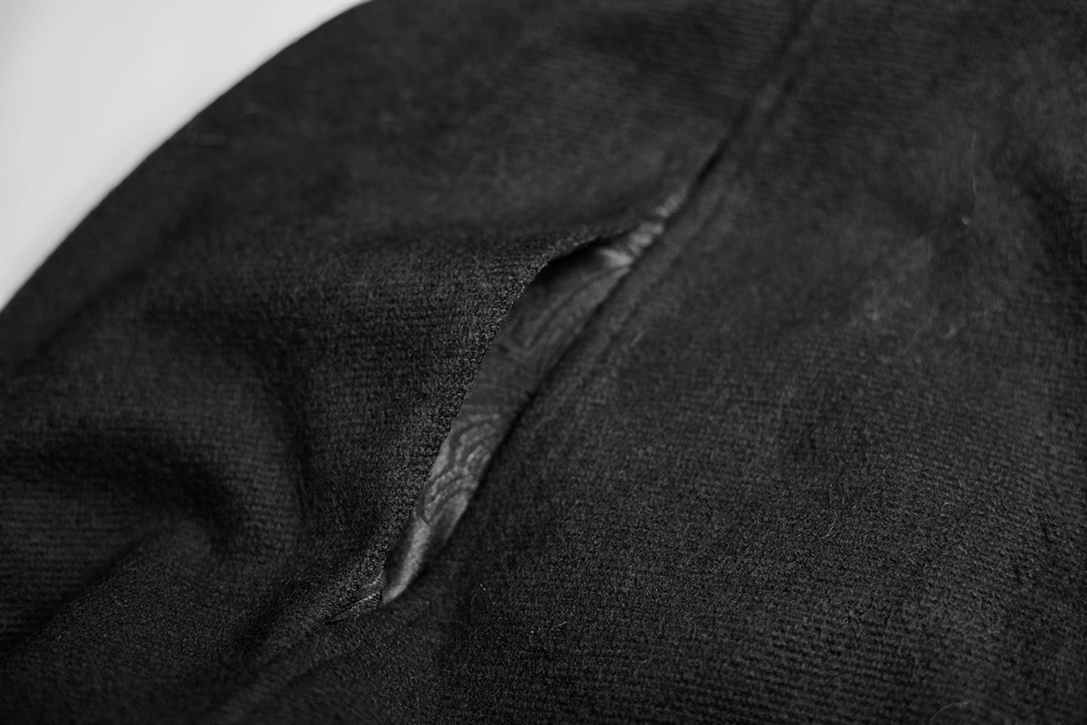 Close-up of a black cloak's fabric showcasing a distinctive opening and soft texture.