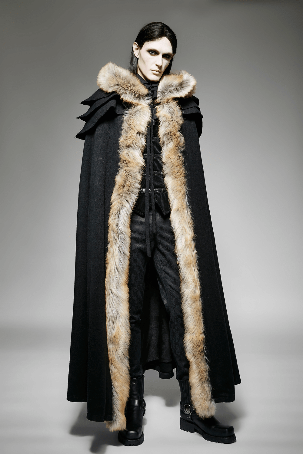 Sophisticated black gothic cloak with faux fur trim, embodying elegance and architectural style in fashion.
