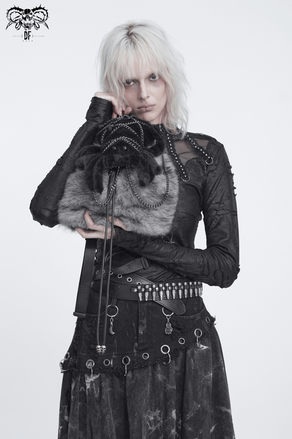 Spider Backpack with Faux Fur and Metal Chain Details held by a model in punk attire with a fierce expression.