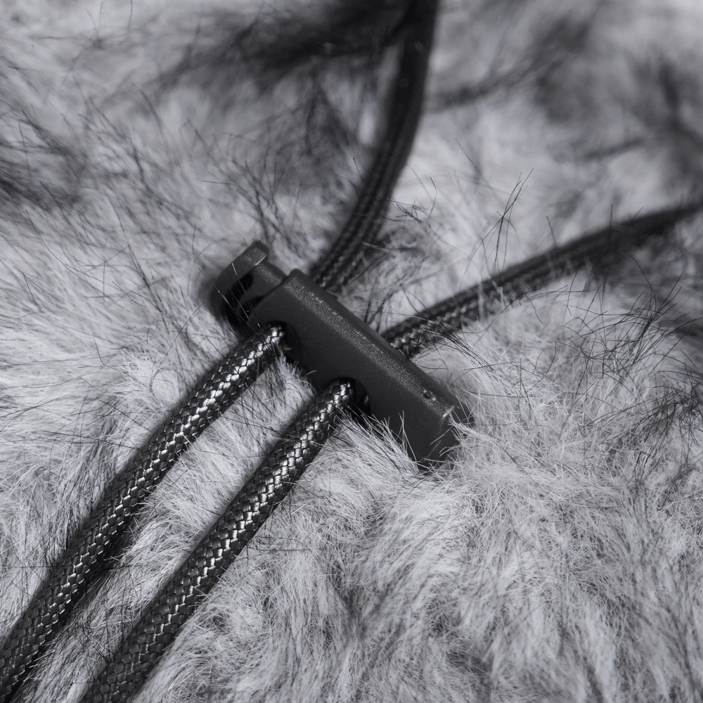 Close-up of the fuzzy grey fabric and adjustable cords of the Spider Backpack with Faux Fur and Metal Chain Details.