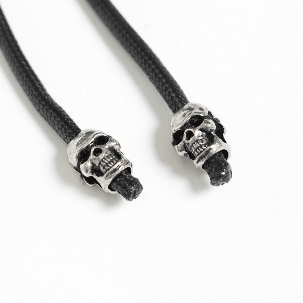 Skull charm details on black braided cords for gothic fashion accessories.