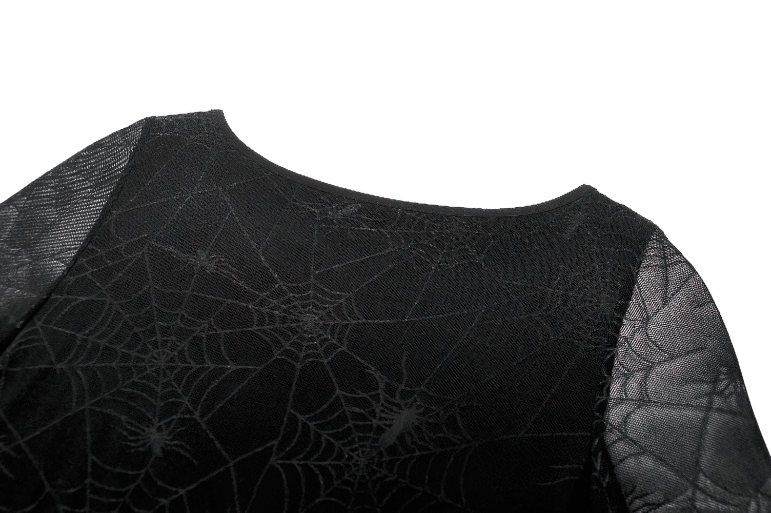 Close-up of spiderweb lace fabric on a dress featuring sheer sleeves and straps.