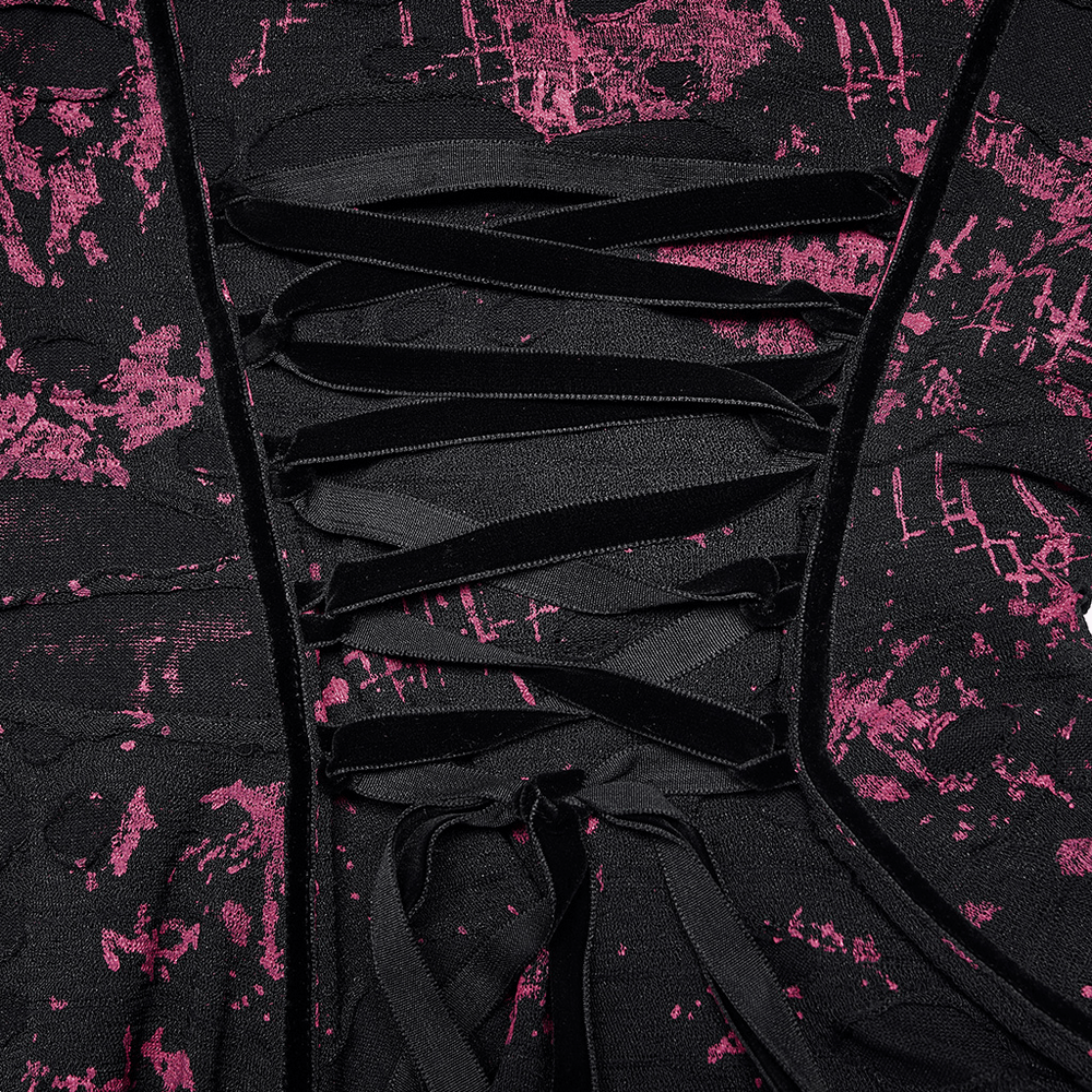 Close-up of pink splatter print gothic dress showcasing lace-up back design and textured fabric details.