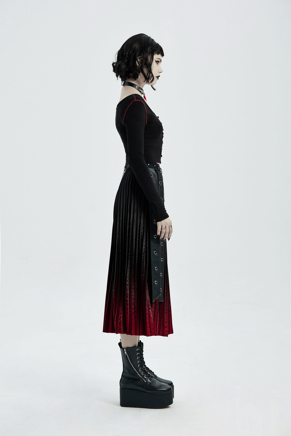 Stylish woman in a black and red gradient punk skirt, showcasing edgy fashion and bold footwear.