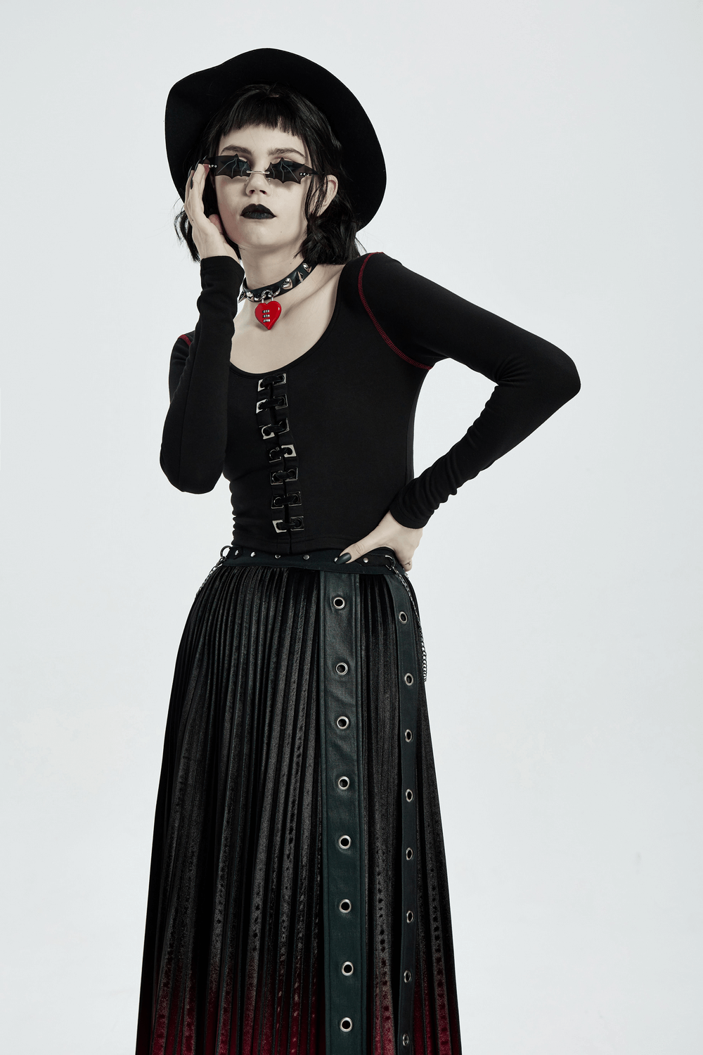 Model showcasing a punk crop top with square eyelet accents and a dramatic skirt, emphasizing edgy style and comfort.
