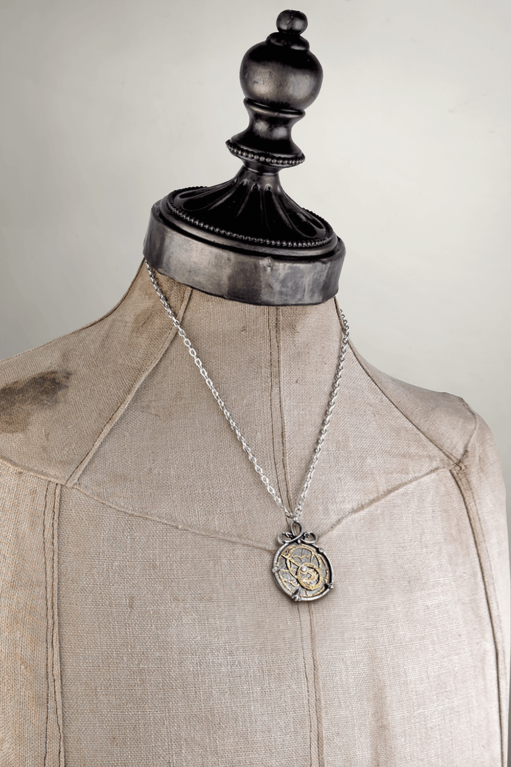 Steampunk Anguistralobe pendant featuring a brass astrolabe dial on a mannequin, showcasing intricate design and elegance.