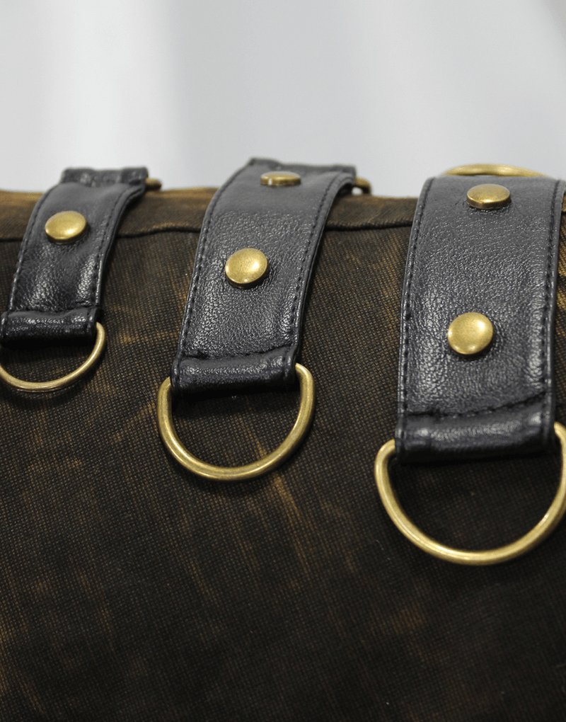 Close-up of steampunk vest straps with bronze rivets and rings, showcasing vintage leather details.