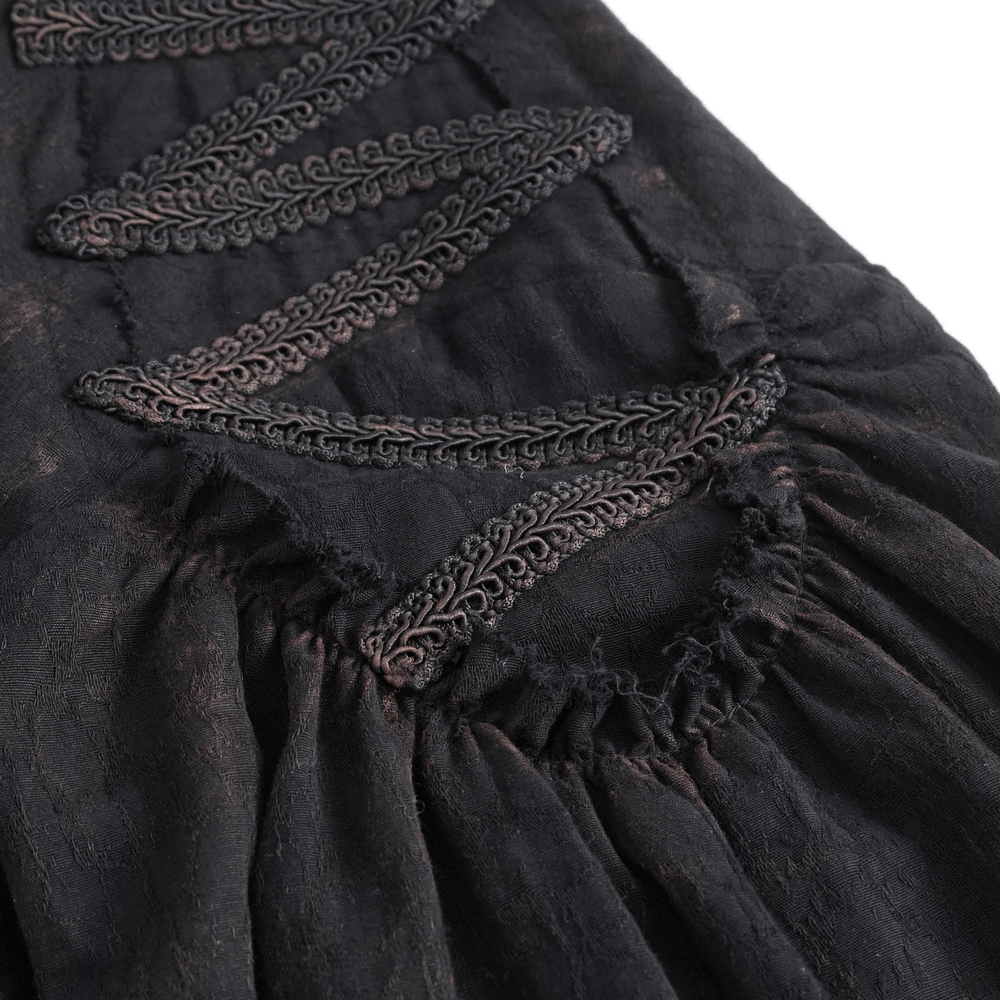 Close-up of steampunk black shirt showing intricate lace detailing and ruffled fabric for a gothic look.