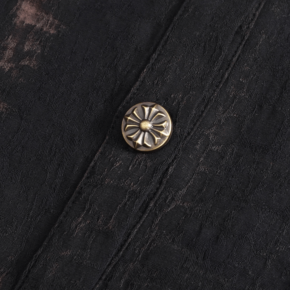 Close-up of decorative metallic button on steampunk black shirt, showcasing intricate design and gothic flair.