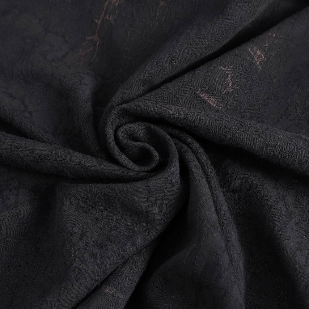 Close-up of textured black fabric with a subtle sheen, perfect for gothic and steampunk fashion designs.
