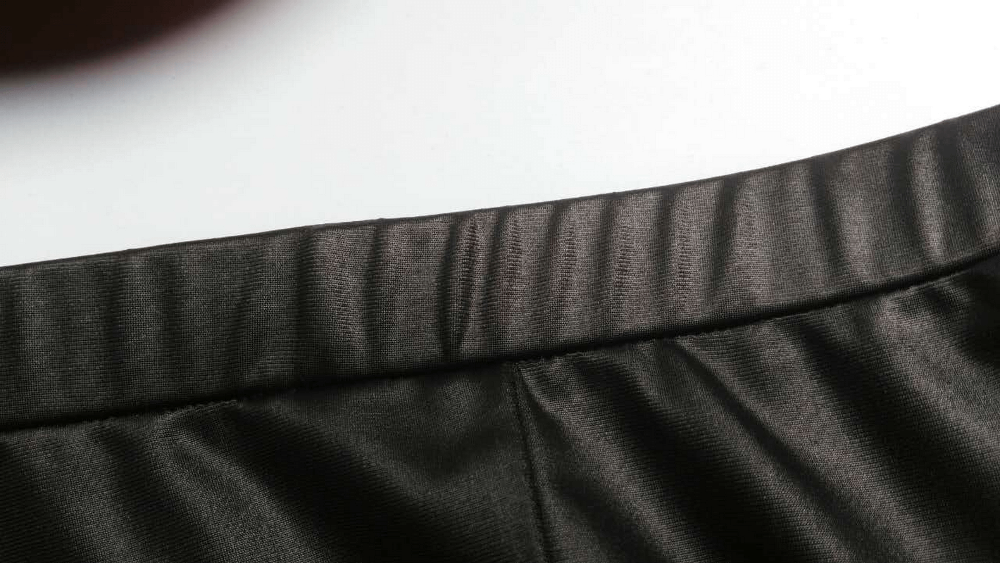 Close-up of the waistband of black steampunk lace leggings with PU leather detail.