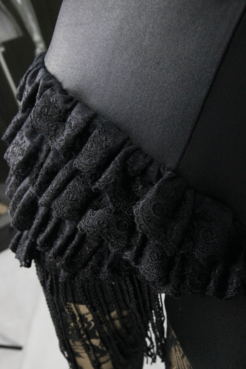 Close-up of steampunk black leggings featuring lace ruffles and PU leather accents for a fashionable look.