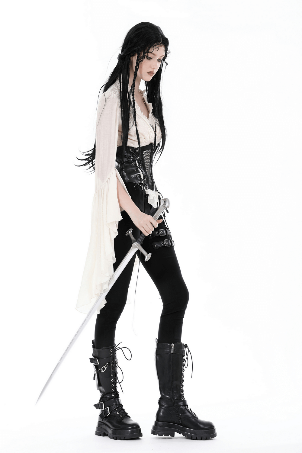 Steampunk blouse with bell sleeves and lace details, styled with black pants and combat boots, holding a sword.