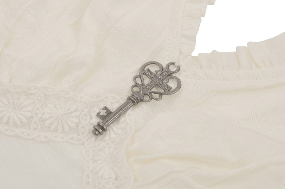 Close-up of a steampunk blouse featuring a vintage silver key and intricate lace detailing.