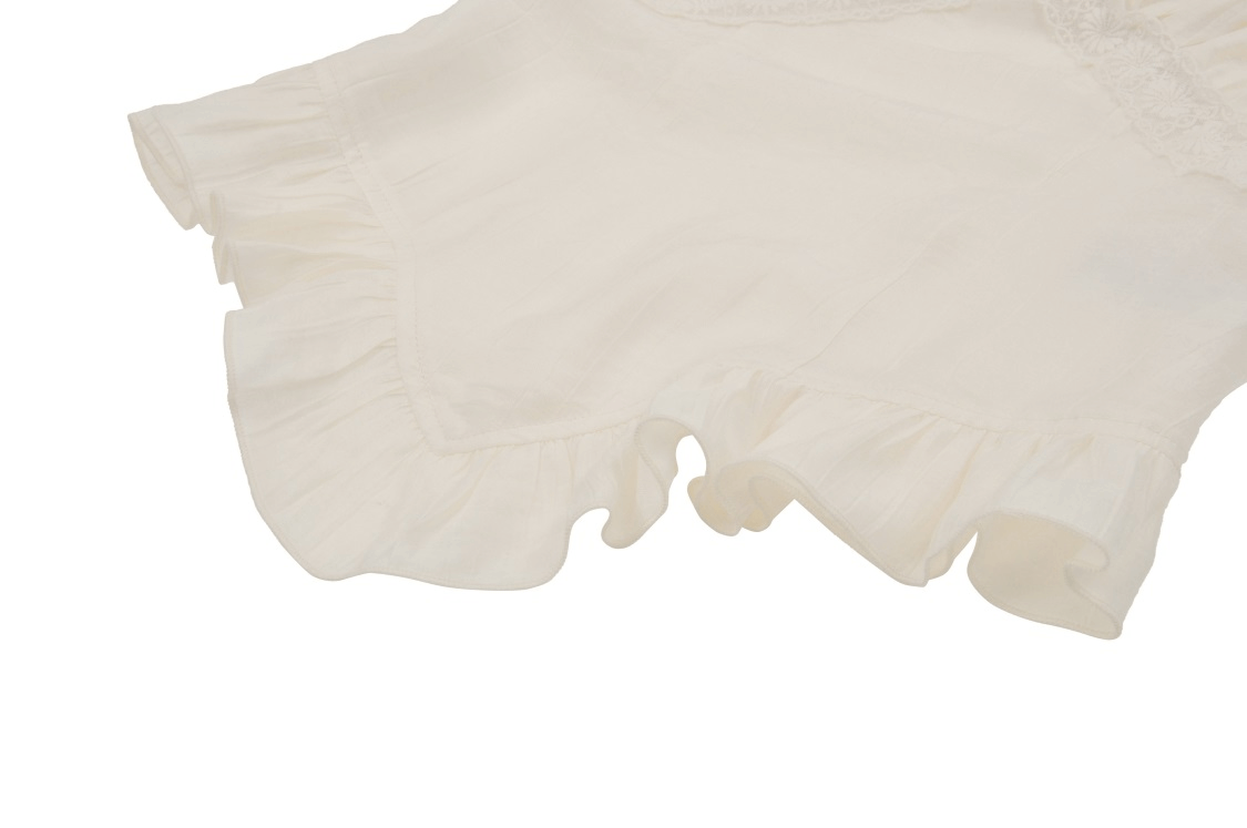 Close-up of a romantic white steampunk blouse with delicate lace and bell-shaped frills, perfect for elegant outfits.