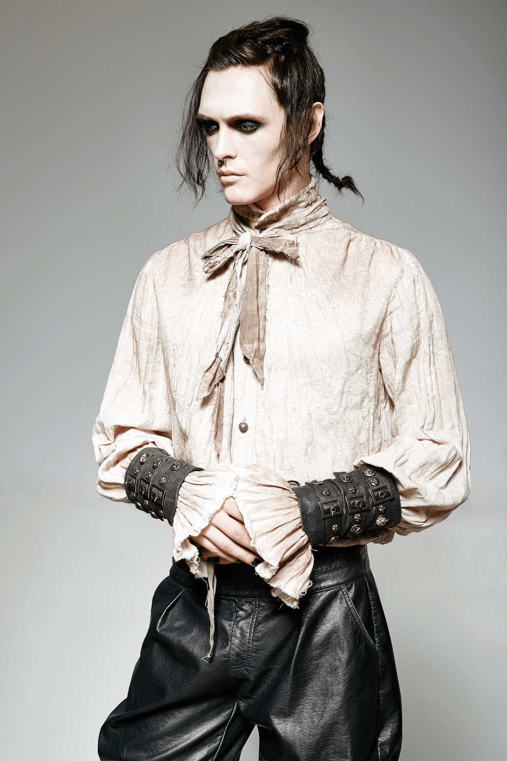 Model showcasing steampunk brown rivet buckle gothic armor bracers with a stylish vintage shirt.