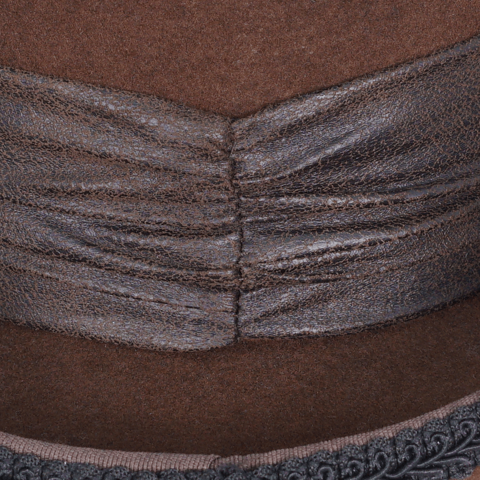 Close-up view of a brown steampunk top hat showing intricate textured leather and detailed seam design.