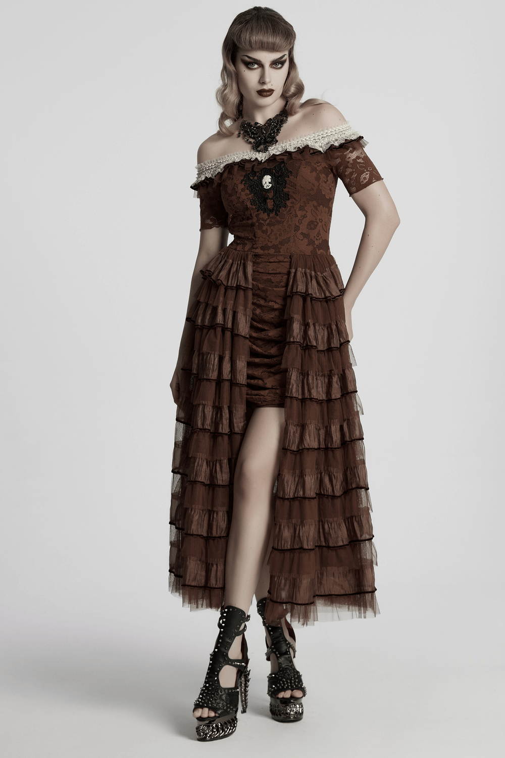 Gothic-inspired off-shoulder brown dress with ruffled layers, accessorized with unique jewelry and stylish shoes.