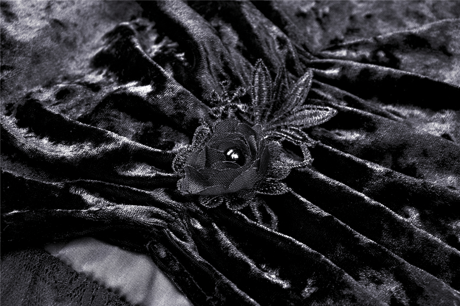 Close-up of the luxurious black velvet fabric with a lace flower detail, perfect for a gothic fashion statement.