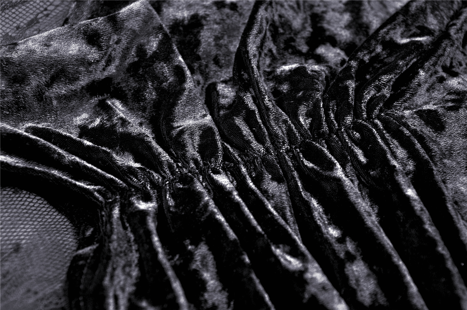 Close-up of luxurious black velvet fabric with elegant ruffles, ideal for a steampunk gothic maxi skirt.