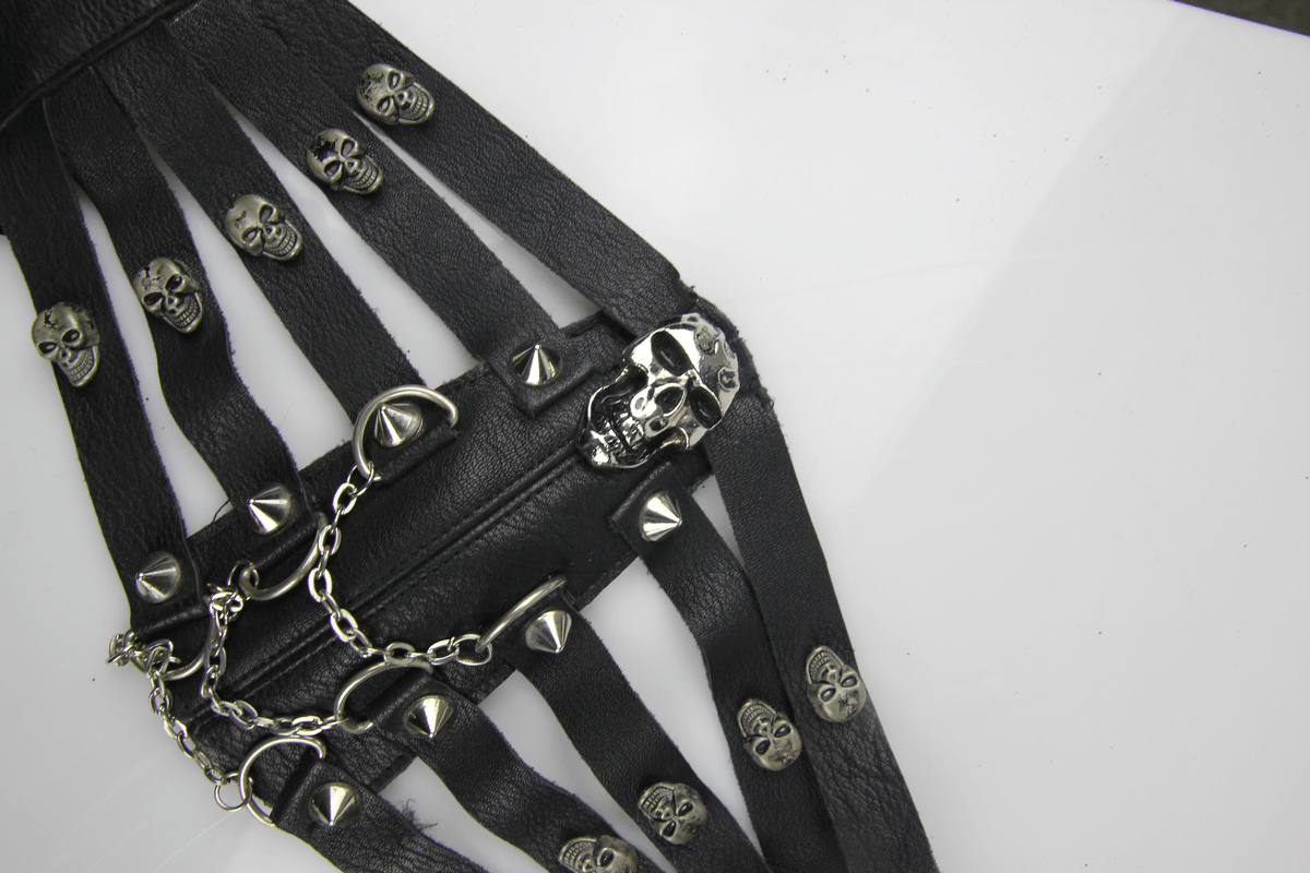 Close-up of a steampunk-inspired black leather mask with silver skulls and spikes accentuating a unique design.