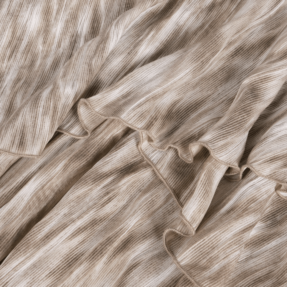 close-up of flowing, textured fabric in beige tones, showcasing ruffled edges for a layered look in a steampunk maxi skirt.