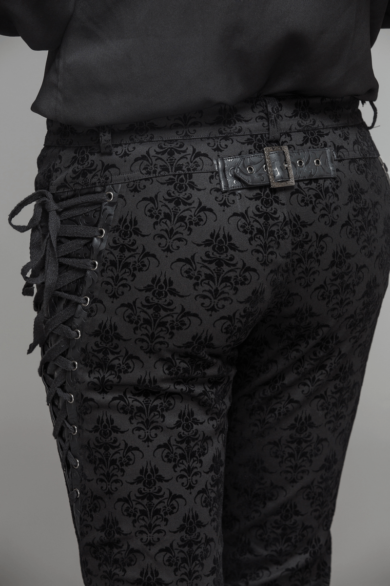 Close-up of gothic black slim pants featuring lace-up sides and vintage pattern, perfect for steampunk style.