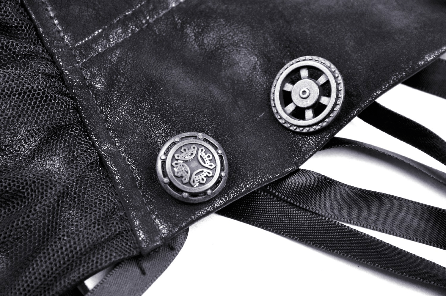 Close-up of steampunk skirt detailing featuring unique buttons and corset lacing in black leather and lace.