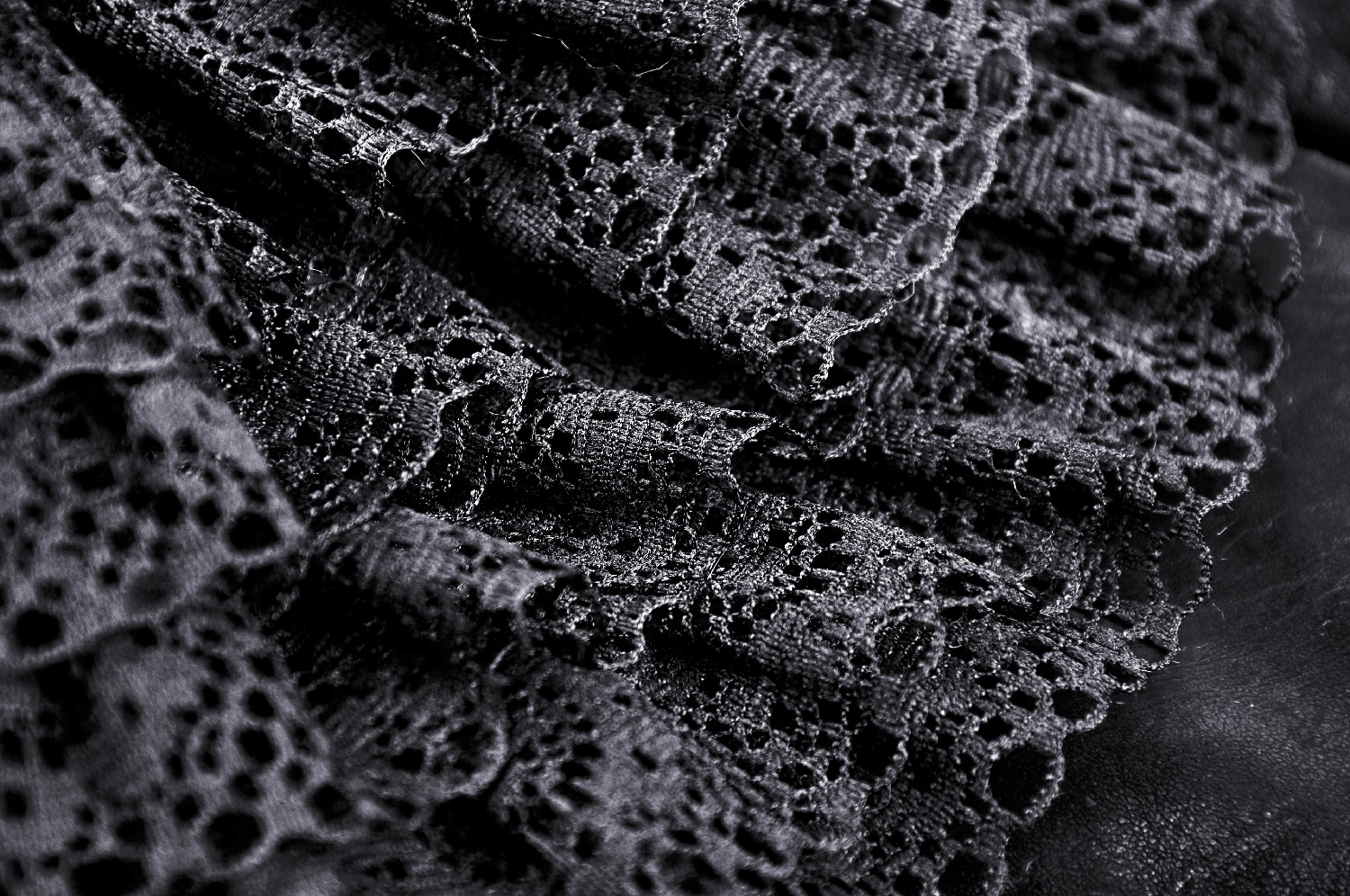 Close-up of black lace ruffles showcasing intricate patterns and texture for a steampunk-inspired skirt.