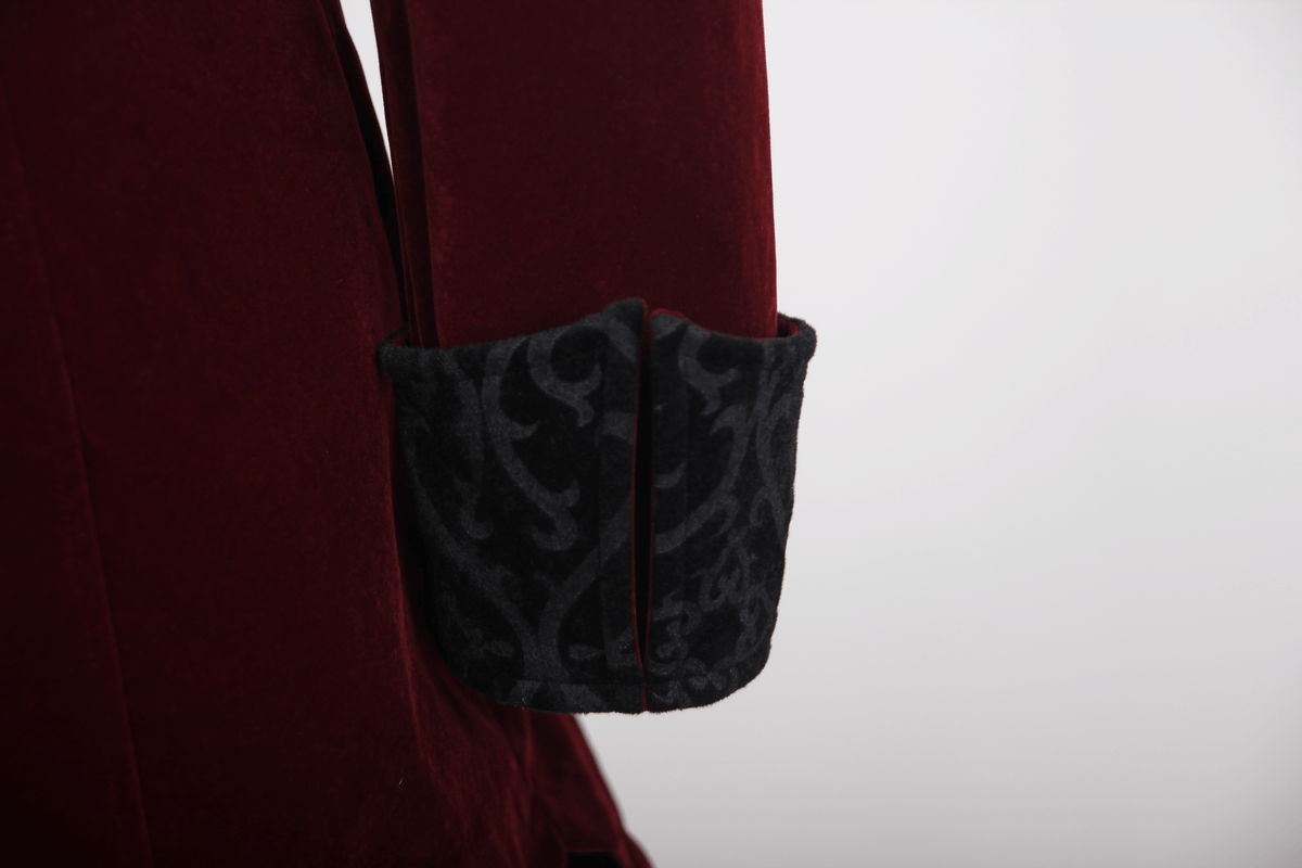 Close-up of the stylish black patterned cuff on a burgundy velvet steampunk coat for men.