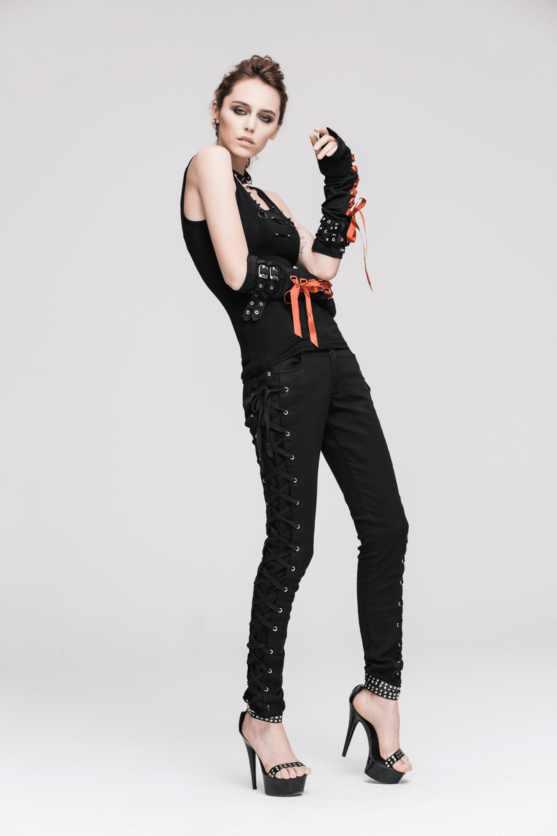 Stylish woman in steampunk-inspired black outfit with spikes and orange accents, showcasing edgy fashion.