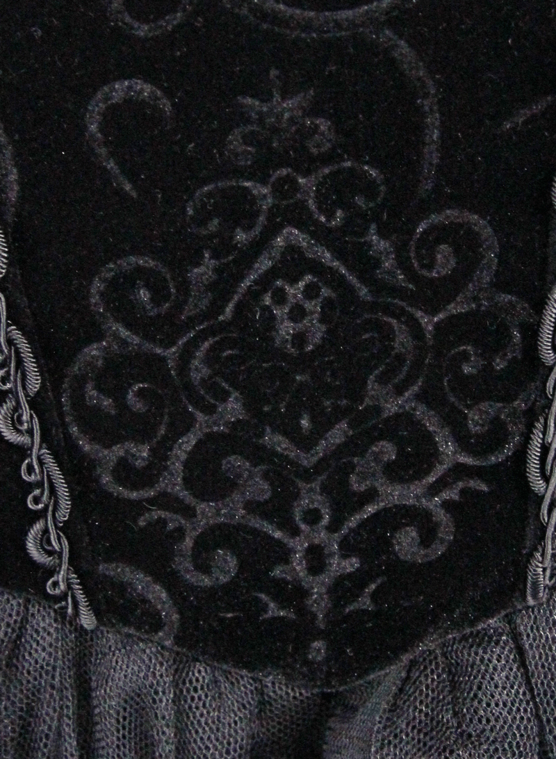 Close-up of intricate black lace detailing on a strapless steampunk dress, showcasing elegant patterns.